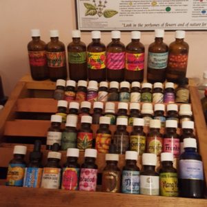 30-40 of my favourite aromatherapy oils in bottles, stacked on wooden shelves