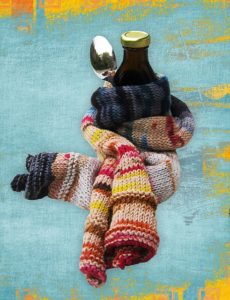medicine and spoon wrapped in a comforting scarf to represent natural cold and flu treatments