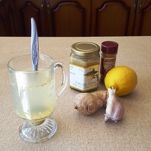 picture of Dorothy Hall's cold and flu remedy made up in a glass, with ingredients in the background